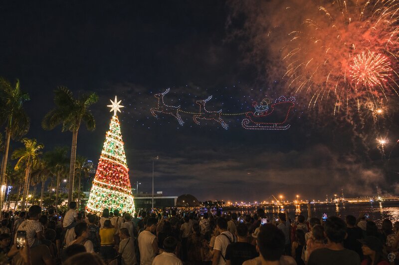 A holiday drone-and-fireworks show lighting up the night sky over Manila Bay with a giant lit Christmas tree below