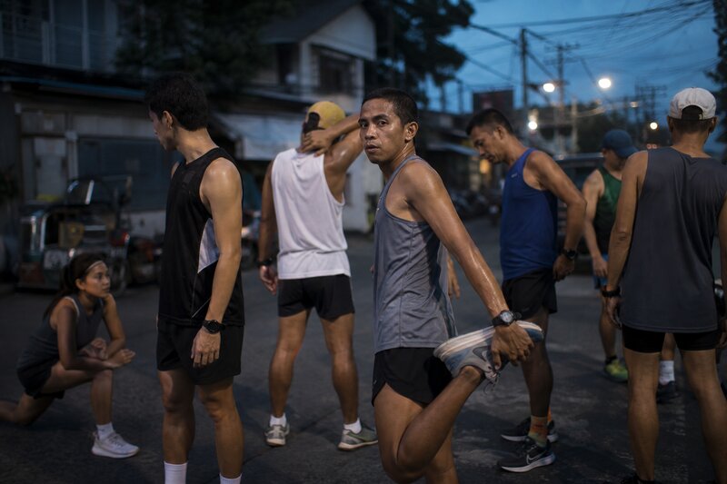 A group of runners stretching and warming up together before a run